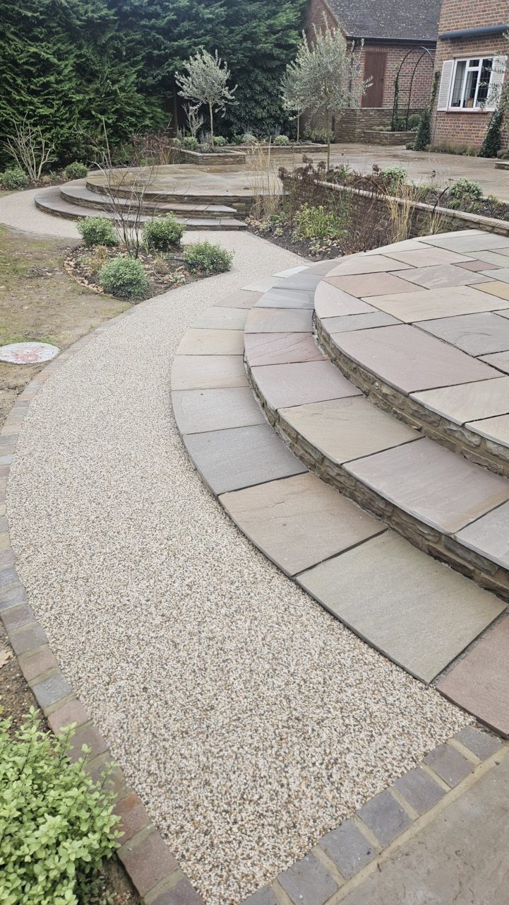 A new path constructed around rear garden of a laxury house in Chalfont. A skilled paver had laid a beautiful sandstone patio, with tiered levels and curved step details. Granite sett edgings forming the path detail enhanced with the natural stone incorporated in the Sureset blend. The new path construction with built to a porous specification using a free draining Mot type 3 sub base, 20mm open graded macadam base course, 10mm porous surface course and finaly the Sureset surface course. The blend was a 4- 6mm aggregate size Winter Bronze blend laid with our acrylic bladed power flot to achieve optimal compaction and surface integrity. The use of mechancial floats always achieves a billiard table type finish in order for us to bring Quality to the Surface!